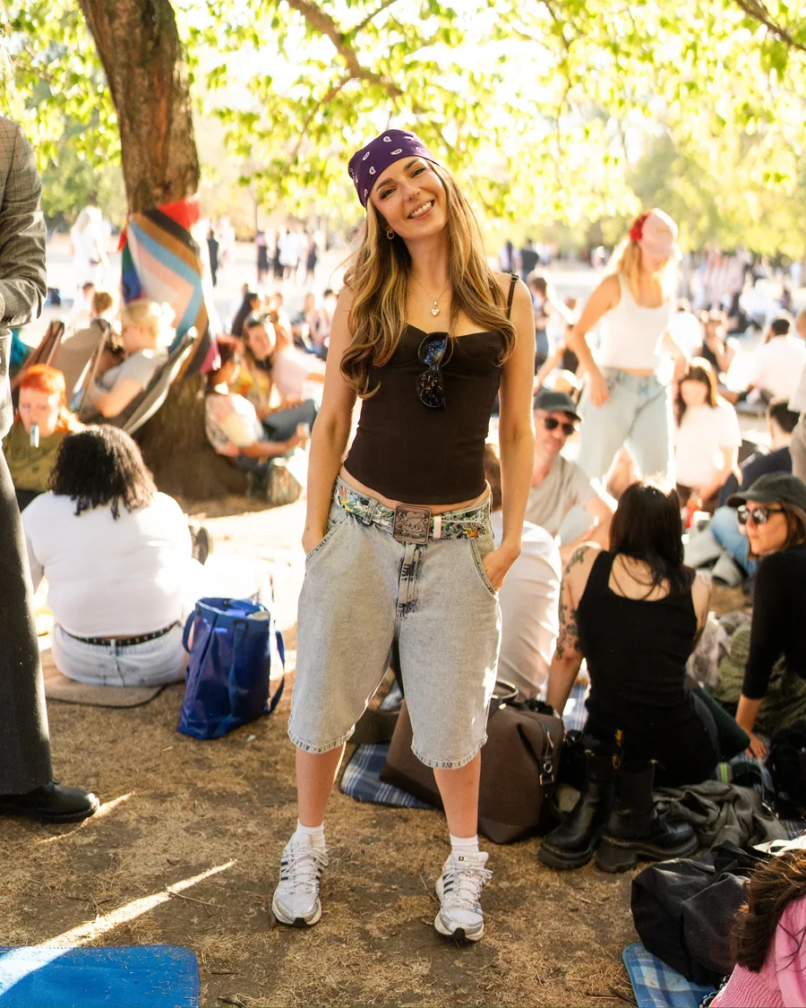 Abi at an outdoor community gathering, with people picnicking in the background.